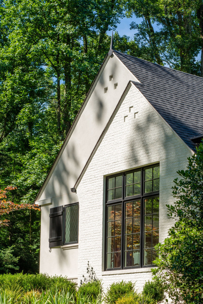 Imagen de fachada de casa beige y negra extra grande de dos plantas con revestimiento de estuco y tejado de teja de madera