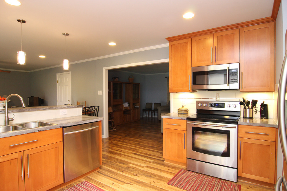 Eat-in kitchen - large transitional u-shaped medium tone wood floor eat-in kitchen idea with a drop-in sink, recessed-panel cabinets, medium tone wood cabinets, laminate countertops, white backsplash, ceramic backsplash, stainless steel appliances and a peninsula