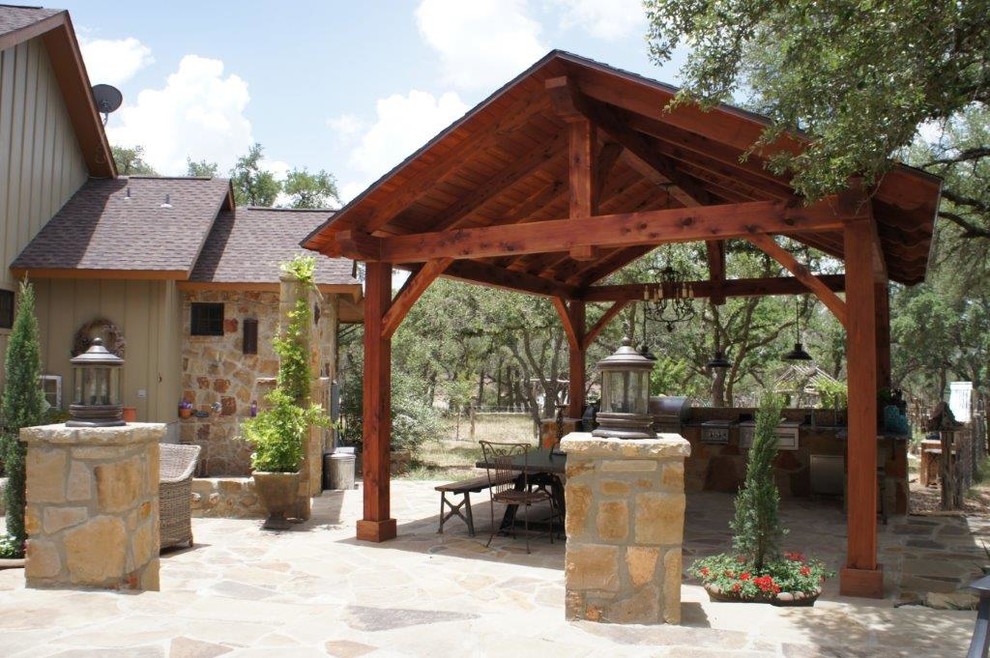 Photo of a large arts and crafts backyard patio in Austin with an outdoor kitchen, natural stone pavers and a gazebo/cabana.