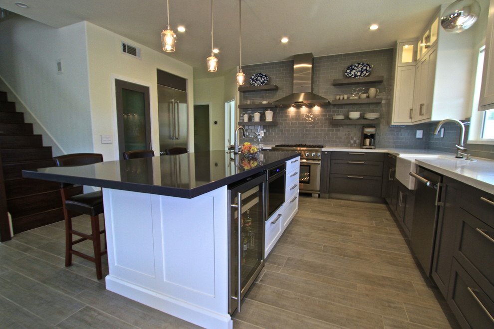 Transitional porcelain tile kitchen photo in Orange County with glass tile backsplash and an island
