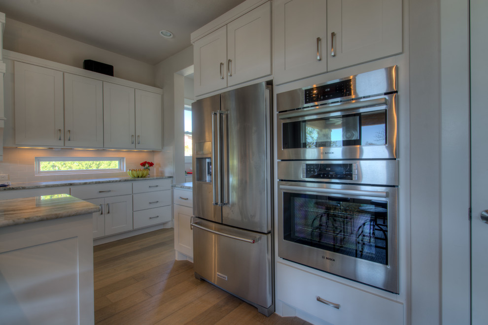 Transitional eat-in kitchen photo in Austin with stainless steel appliances and an island