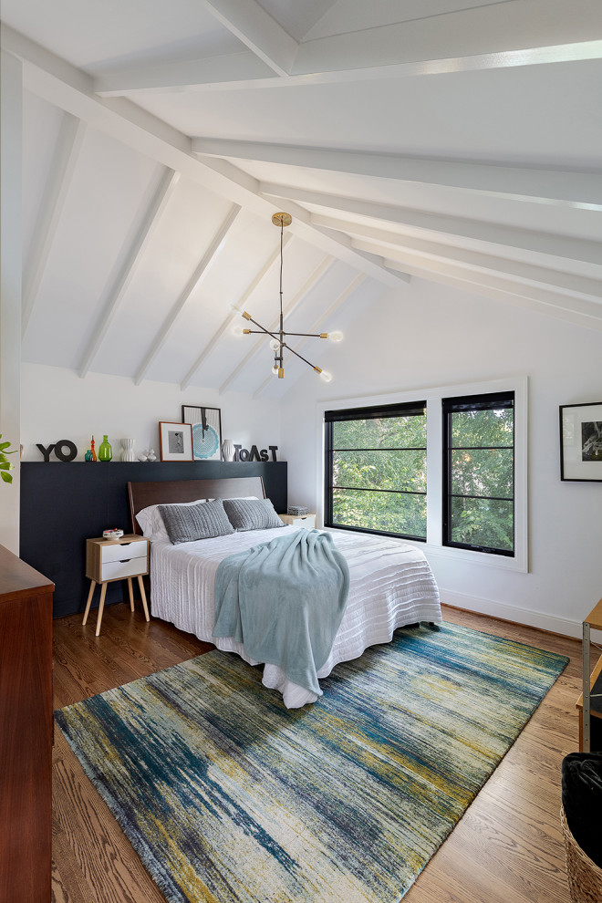 Mittelgroßes Mid-Century Hauptschlafzimmer mit weißer Wandfarbe, braunem Holzboden, braunem Boden und freigelegten Dachbalken in Detroit