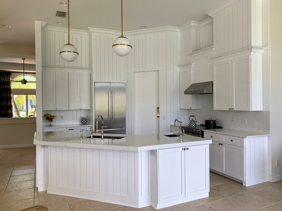 Small beach style u-shaped open plan kitchen in Miami with an integrated sink, shaker cabinets, white cabinets, quartzite benchtops, white splashback, shiplap splashback, stainless steel appliances, porcelain floors, with island, beige floor and white benchtop.