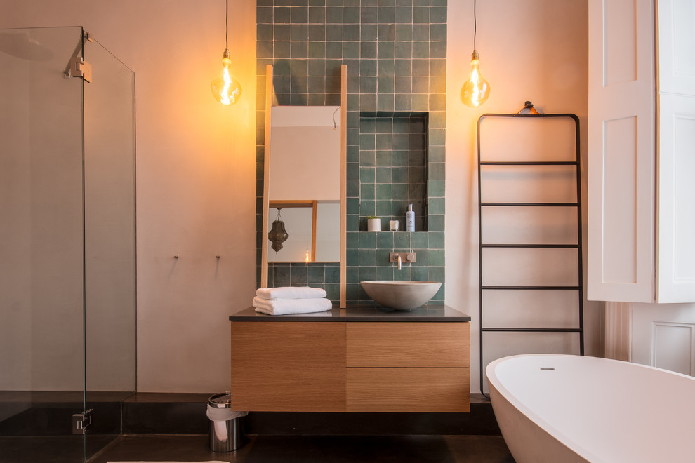 This is an example of a large traditional 3/4 bathroom in London with furniture-like cabinets, brown cabinets, a freestanding tub, an open shower, a wall-mount toilet, brown tile, terra-cotta tile, beige walls, a wall-mount sink, wood benchtops, beige floor and an open shower.