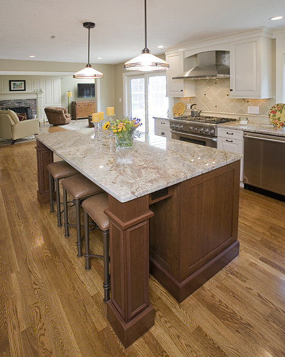 This is an example of a large traditional l-shaped eat-in kitchen in Boston with a farmhouse sink, shaker cabinets, white cabinets, marble benchtops, white splashback, ceramic splashback, stainless steel appliances, dark hardwood floors and with island.