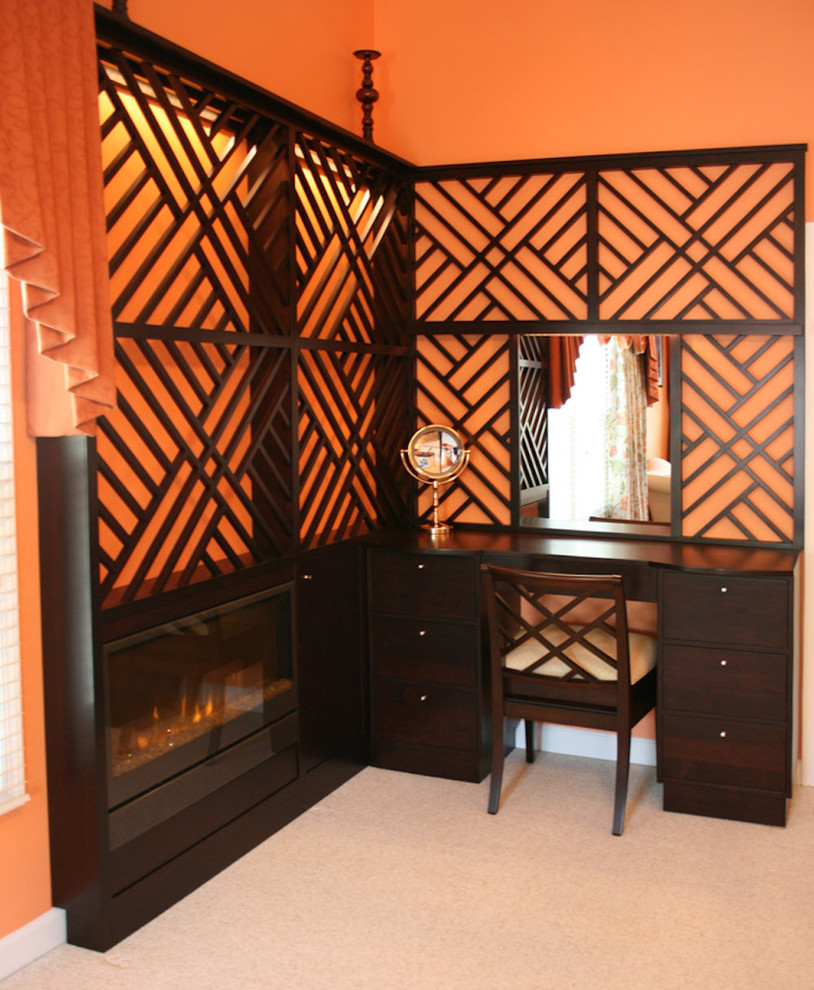 Inspiration for a mid-sized eclectic guest bedroom in DC Metro with orange walls, carpet, a ribbon fireplace, a wood fireplace surround and grey floor.