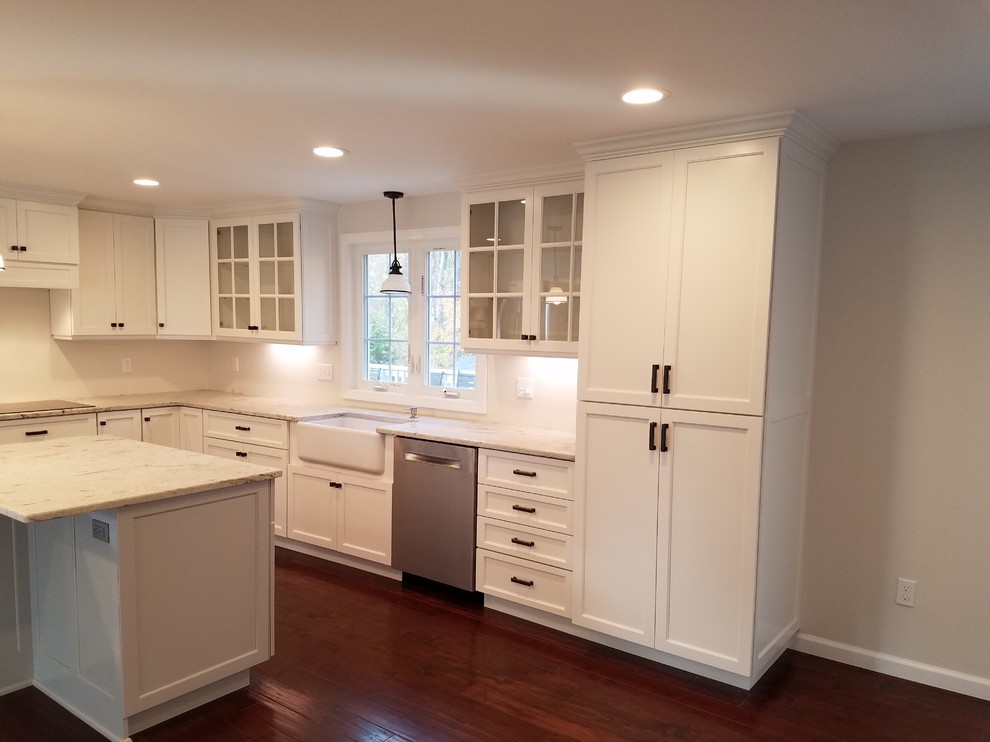 Inspiration for a mid-sized transitional l-shaped dark wood floor and brown floor eat-in kitchen remodel with a farmhouse sink, shaker cabinets, white cabinets, granite countertops, white backsplash, subway tile backsplash, stainless steel appliances and an island