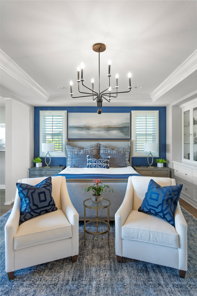Ispirazione per una grande camera matrimoniale classica con pareti blu e pavimento in legno massello medio