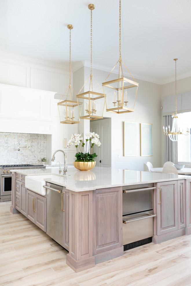 Inspiration for a large transitional porcelain tile and beige floor kitchen remodel in Orlando with a farmhouse sink, recessed-panel cabinets, white cabinets, quartzite countertops, multicolored backsplash, marble backsplash, stainless steel appliances, an island and beige countertops