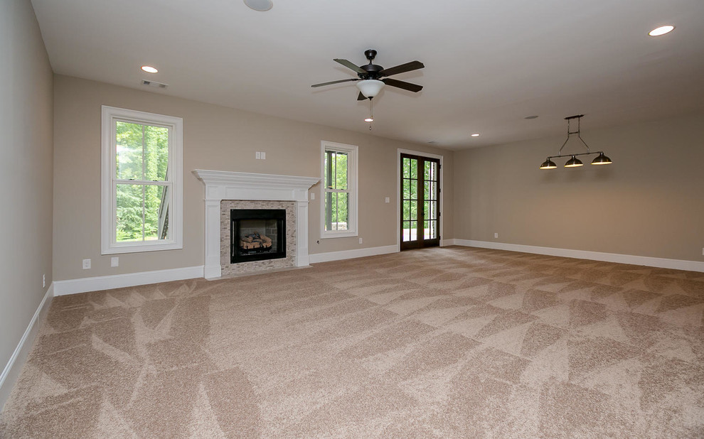 Traditional walk-out basement in Atlanta with beige walls, carpet, a standard fireplace and a tile fireplace surround.