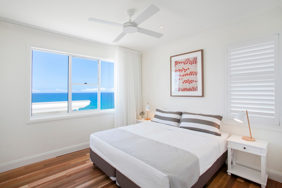 Inspiration for a mid-sized beach style guest bedroom in Sunshine Coast with white walls and medium hardwood floors.