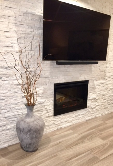 This is an example of a mid-sized transitional enclosed living room in Phoenix with beige walls, vinyl floors, a standard fireplace, a stone fireplace surround and a wall-mounted tv.