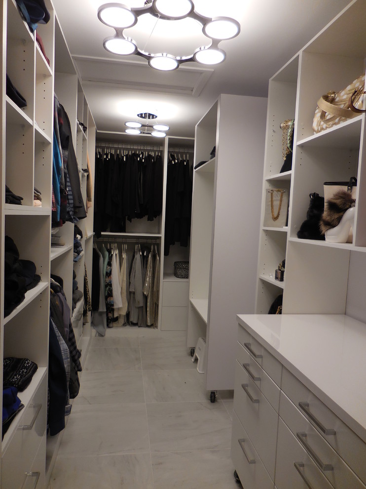 Design ideas for a mid-sized modern walk-in wardrobe in Montreal with flat-panel cabinets, white cabinets and ceramic floors.