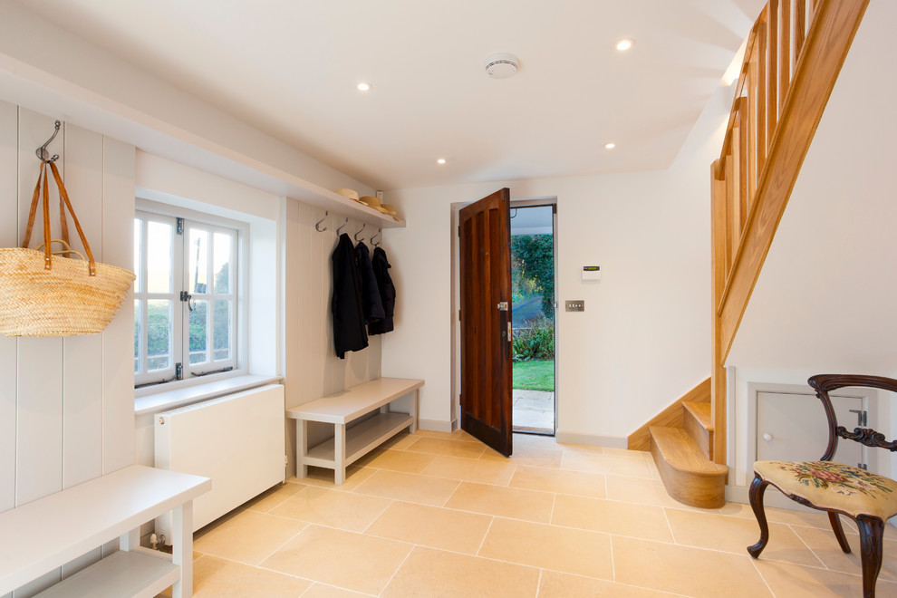 This is an example of a mid-sized country hallway in Kent with white walls and limestone floors.