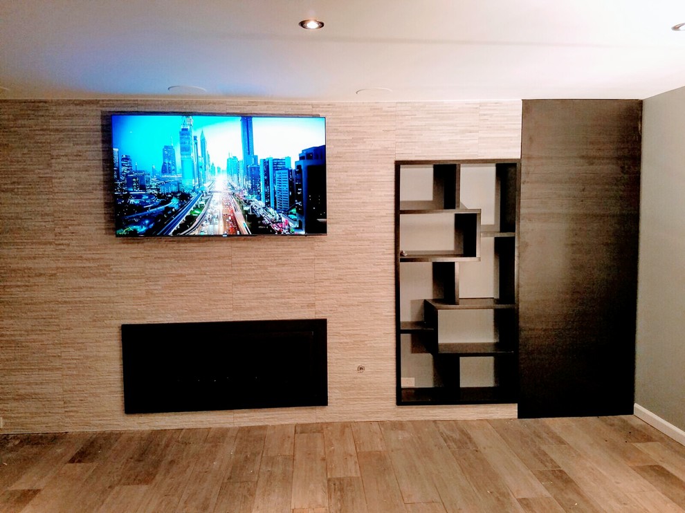 This is an example of a mid-sized modern home theatre in New York with a built-in media wall.
