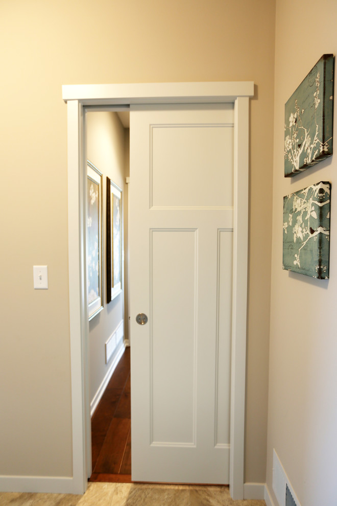 Photo of an arts and crafts hallway in Minneapolis with beige walls and medium hardwood floors.
