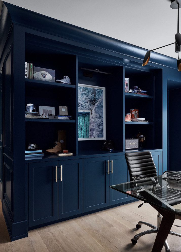 На фото: большая домашняя мастерская в стиле неоклассика (современная классика) с синими стенами, светлым паркетным полом, отдельно стоящим рабочим столом и панелями на части стены без камина с
