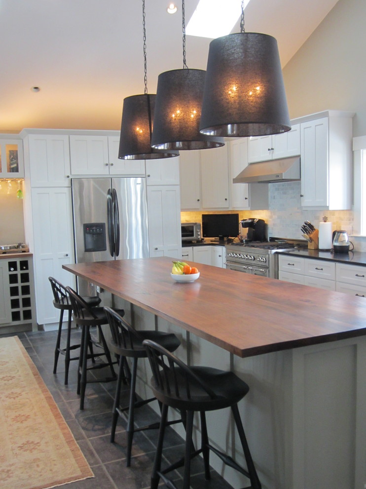Photo of a large transitional u-shaped eat-in kitchen in Boston with an undermount sink, shaker cabinets, white cabinets, granite benchtops, multi-coloured splashback, stone tile splashback, stainless steel appliances, slate floors, with island and grey floor.
