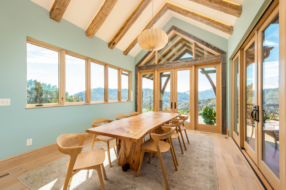 Diseño de comedor abovedado contemporáneo con paredes azules, suelo de madera clara, suelo beige y vigas vistas