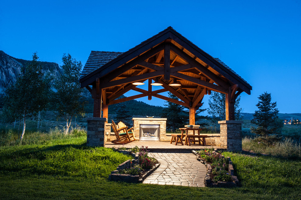 Country patio in Denver with a fire feature and a gazebo/cabana.
