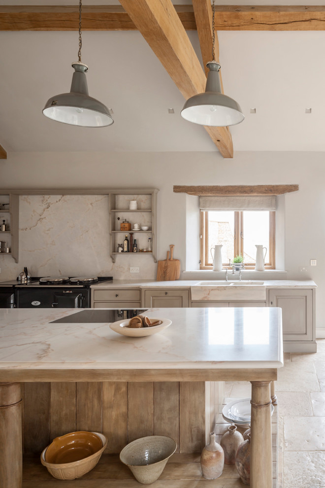 Photo of a large country galley open plan kitchen in Gloucestershire with a single-bowl sink, raised-panel cabinets, marble benchtops, white splashback, stone slab splashback, stainless steel appliances, limestone floors, with island and light wood cabinets.