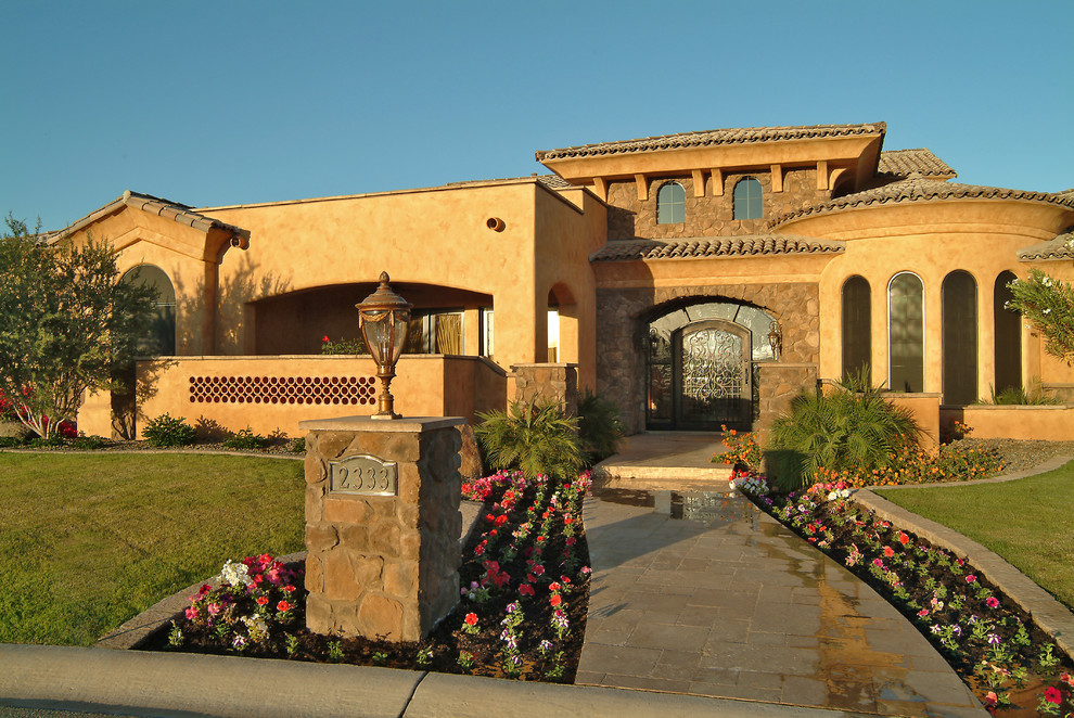 Example of a mid-sized transitional yellow one-story stucco gable roof design in Phoenix