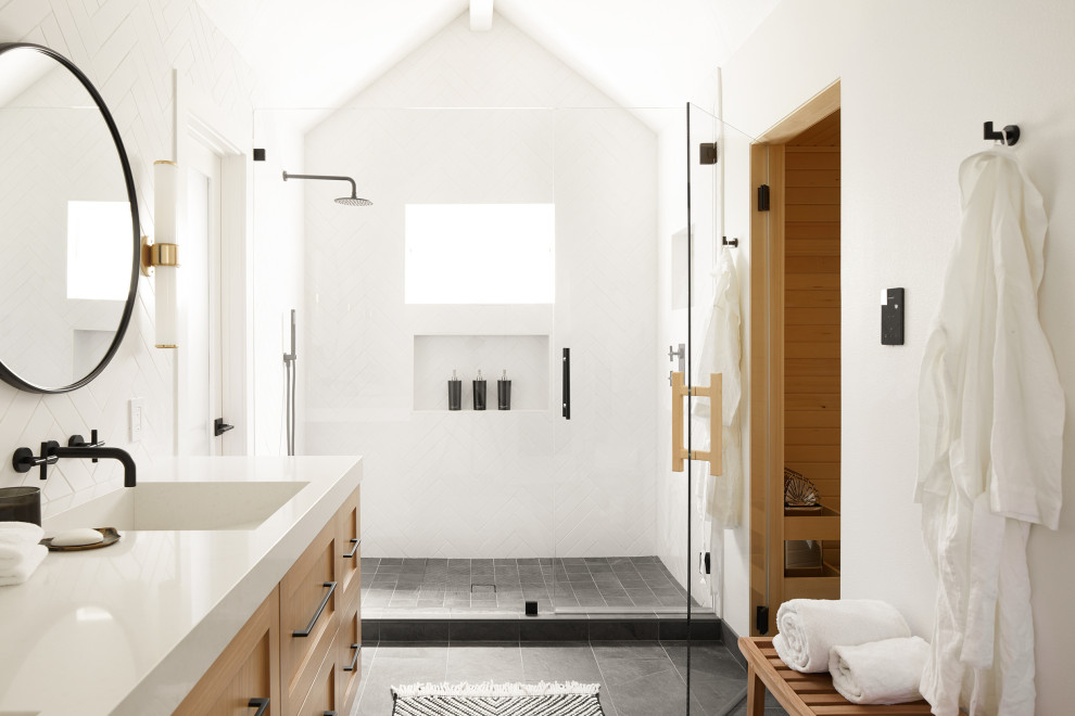 Photo of a large farmhouse ensuite bathroom in San Francisco with flat-panel cabinets, light wood cabinets, a wall mounted toilet, white tiles, ceramic tiles, white walls, porcelain flooring, a submerged sink, quartz worktops, grey floors, an open shower, white worktops, a wall niche, double sinks and a floating vanity unit.