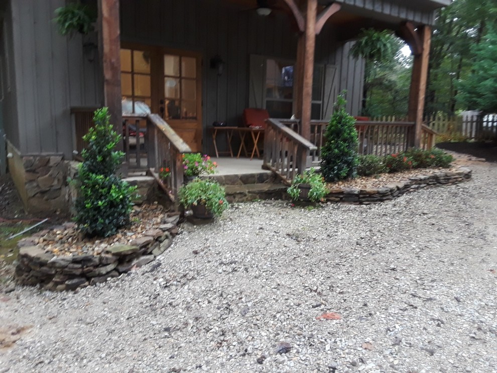 Inspiration for a rustic front yard stone landscaping.