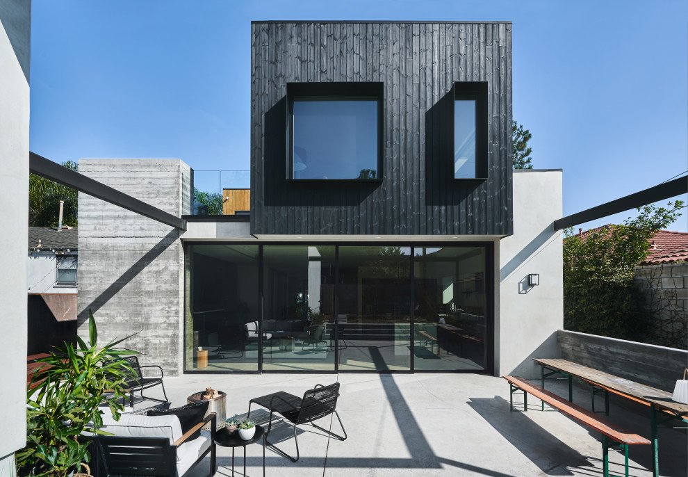 Idéer för att renovera ett mellanstort funkis svart hus, med två våningar, platt tak och tak i mixade material
