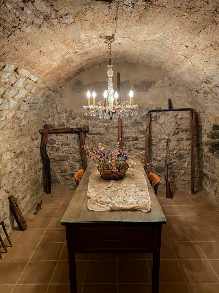 Diseño de sótano en el subsuelo abovedado rural grande sin chimenea con bar en casa, paredes marrones y suelo marrón