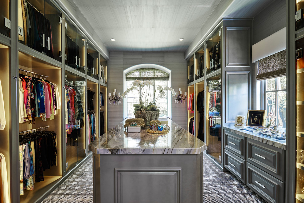 This is an example of a large transitional gender-neutral walk-in wardrobe in Dallas with raised-panel cabinets, grey cabinets and carpet.