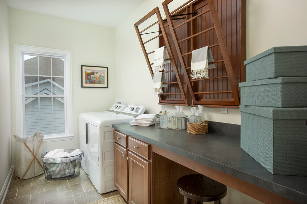 Inspiration for a mid-sized transitional single-wall dedicated laundry room in Columbus with recessed-panel cabinets, medium wood cabinets, laminate benchtops, white walls, travertine floors, a side-by-side washer and dryer and green benchtop.
