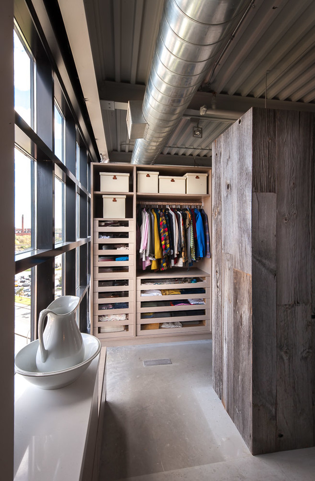 Inspiration for a mid-sized industrial gender-neutral walk-in wardrobe in Toronto with open cabinets and light wood cabinets.