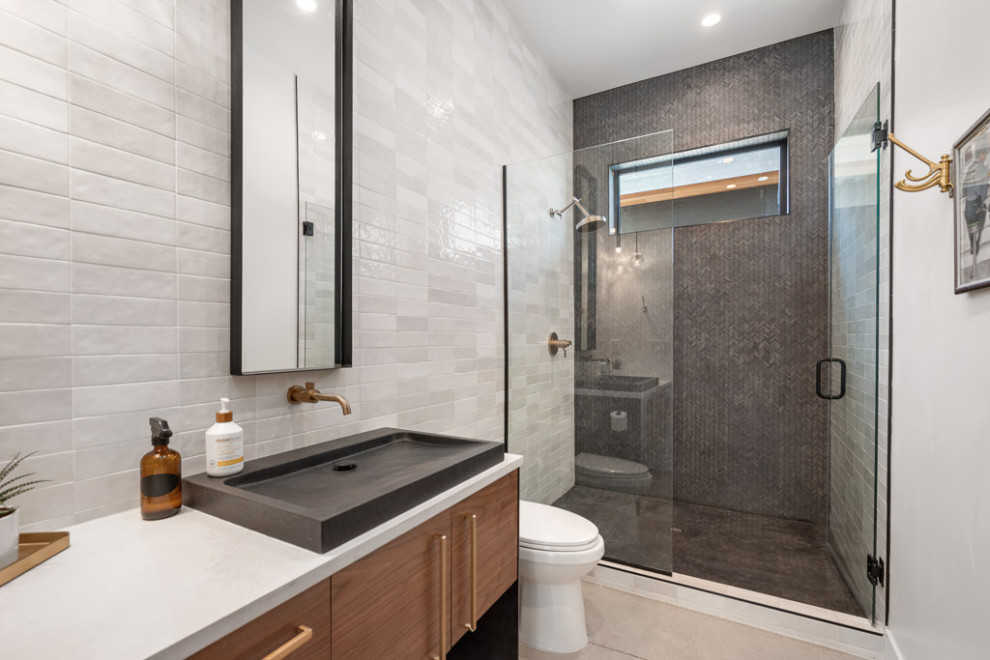 Inspiration for a modern bathroom in Denver with flat-panel cabinets, medium wood cabinets, white tile, subway tile, black walls, porcelain floors, a vessel sink, quartzite benchtops, beige floor, a hinged shower door, white benchtops, a single vanity and a floating vanity.