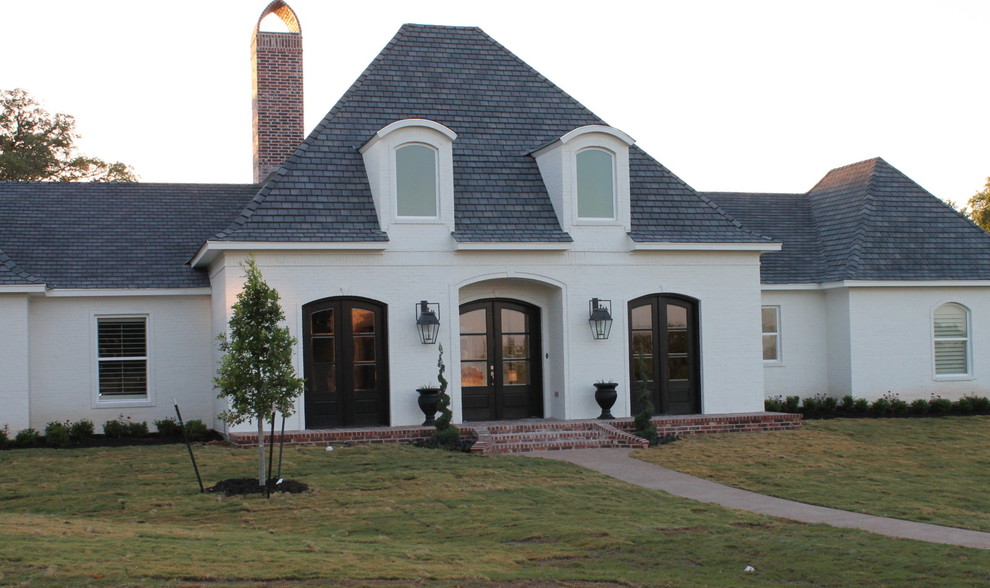 Photo of a large contemporary one-storey stucco white exterior in Austin with a hip roof.