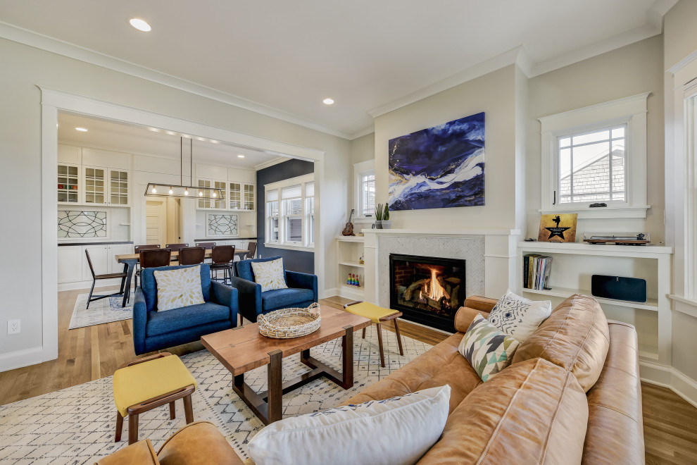 Photo of a large arts and crafts open concept living room in Seattle with white walls, light hardwood floors, a standard fireplace and a tile fireplace surround.