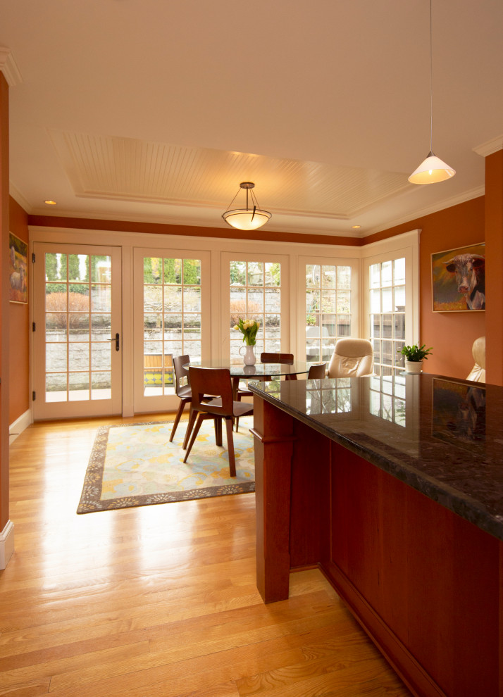 Immagine di una grande sala da pranzo aperta verso la cucina tradizionale con parquet chiaro e pavimento marrone