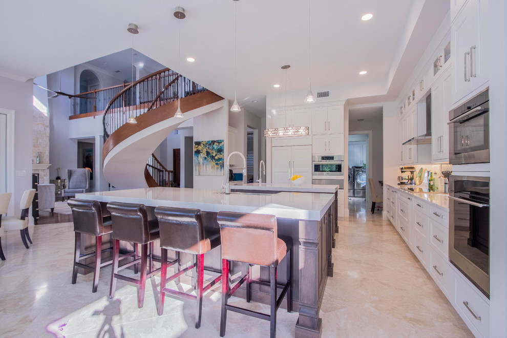 Inspiration for a huge transitional l-shaped porcelain tile and beige floor open concept kitchen remodel with a farmhouse sink, shaker cabinets, white cabinets, quartz countertops, white backsplash, porcelain backsplash, stainless steel appliances and two islands