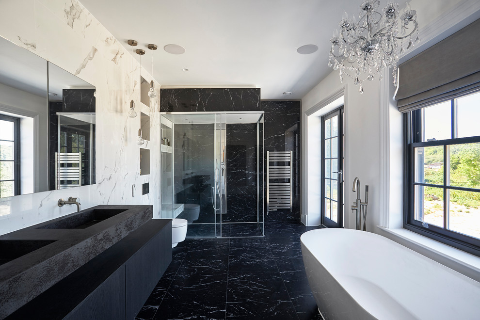 Design ideas for a contemporary 3/4 bathroom in Other with flat-panel cabinets, black cabinets, a freestanding tub, a curbless shower, a wall-mount toilet, white walls, an integrated sink, black floor, a sliding shower screen and black benchtops.