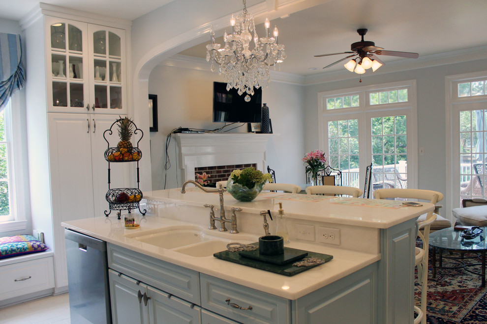This is an example of a mid-sized traditional u-shaped open plan kitchen in Raleigh with a double-bowl sink, raised-panel cabinets, white cabinets, quartzite benchtops, white splashback, glass tile splashback, stainless steel appliances, brick floors and with island.