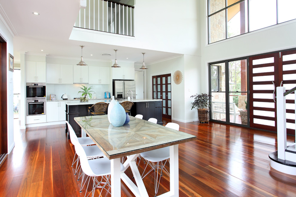 This is an example of a contemporary kitchen/dining combo in Gold Coast - Tweed with white walls and dark hardwood floors.