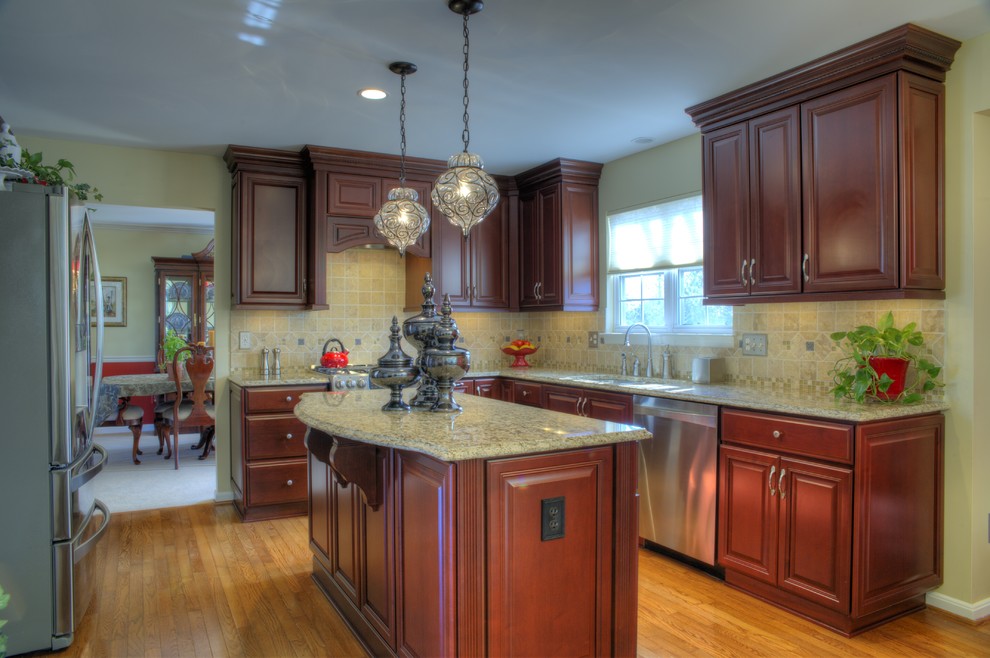 Mid-sized traditional u-shaped eat-in kitchen in DC Metro with an undermount sink, raised-panel cabinets, medium wood cabinets, granite benchtops, beige splashback, stone tile splashback, stainless steel appliances, medium hardwood floors and with island.