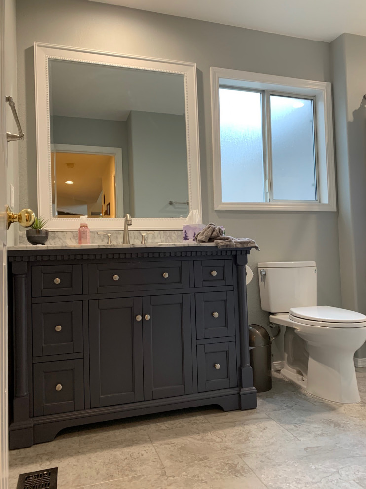 Foto på ett litet vit badrum, med skåp i shakerstil, blå skåp, ett badkar i en alkov, en toalettstol med separat cisternkåpa, grå väggar, vinylgolv, ett integrerad handfat, bänkskiva i akrylsten och grått golv