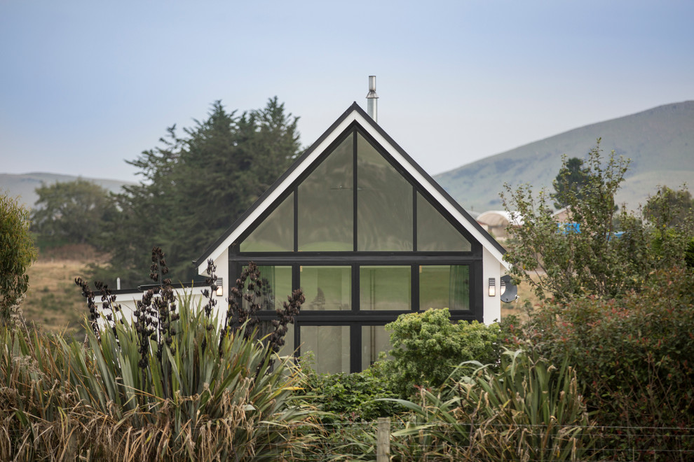 Inspiration for a small modern one-storey concrete white exterior in Dunedin with a gable roof.