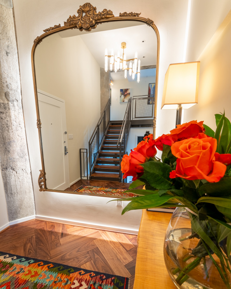 Small transitional medium tone wood floor and brown floor foyer photo in Baltimore with beige walls and a white front door