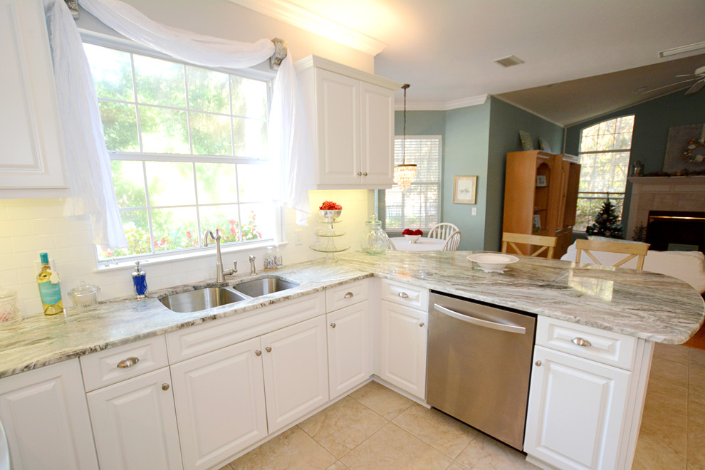 Inspiration for a mid-sized traditional u-shaped eat-in kitchen in Jacksonville with an undermount sink, raised-panel cabinets, white cabinets, granite benchtops, white splashback, ceramic splashback, stainless steel appliances, ceramic floors and a peninsula.