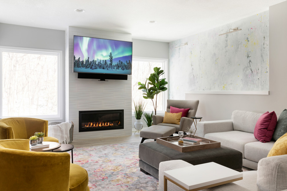 This is an example of a mid-sized modern walk-out basement in Minneapolis with grey walls, vinyl floors, a standard fireplace, a tile fireplace surround and brown floor.