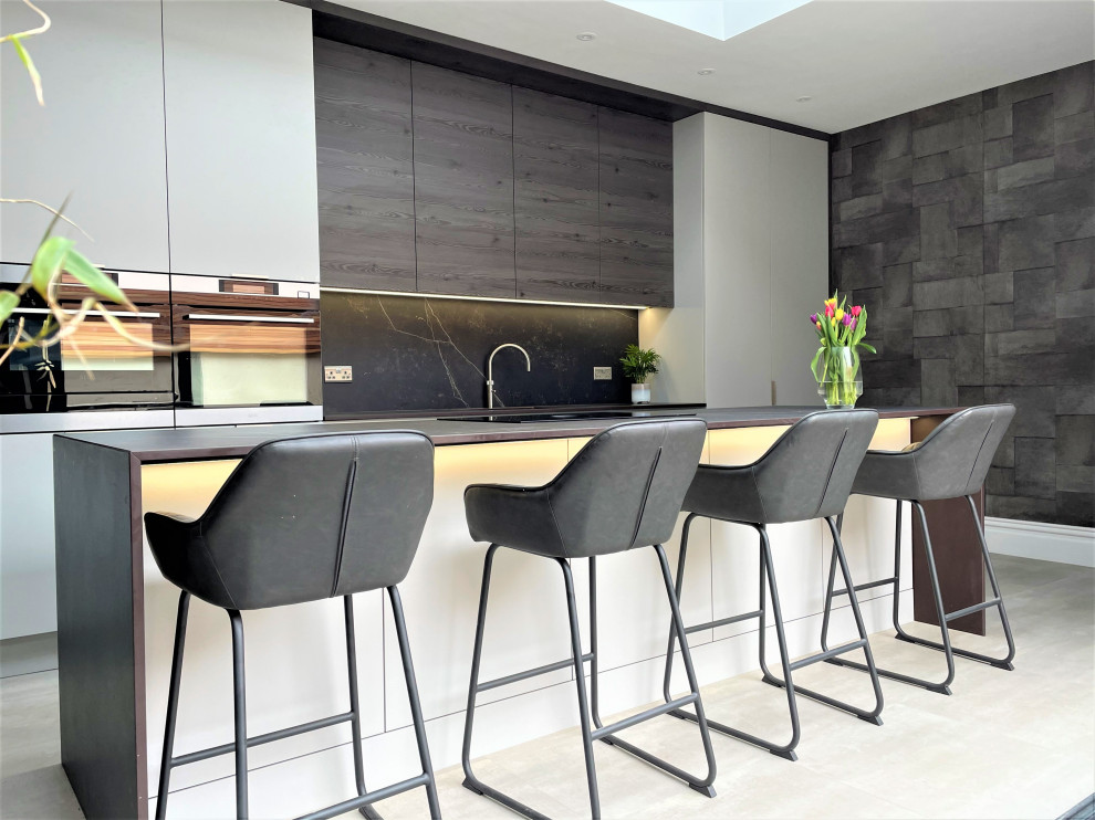 Exemple d'une grande cuisine ouverte linéaire tendance en bois brun avec un évier 1 bac, un placard à porte plane, un plan de travail en quartz modifié, une crédence grise, un électroménager noir, un sol en vinyl, îlot, un sol gris et un plan de travail gris.