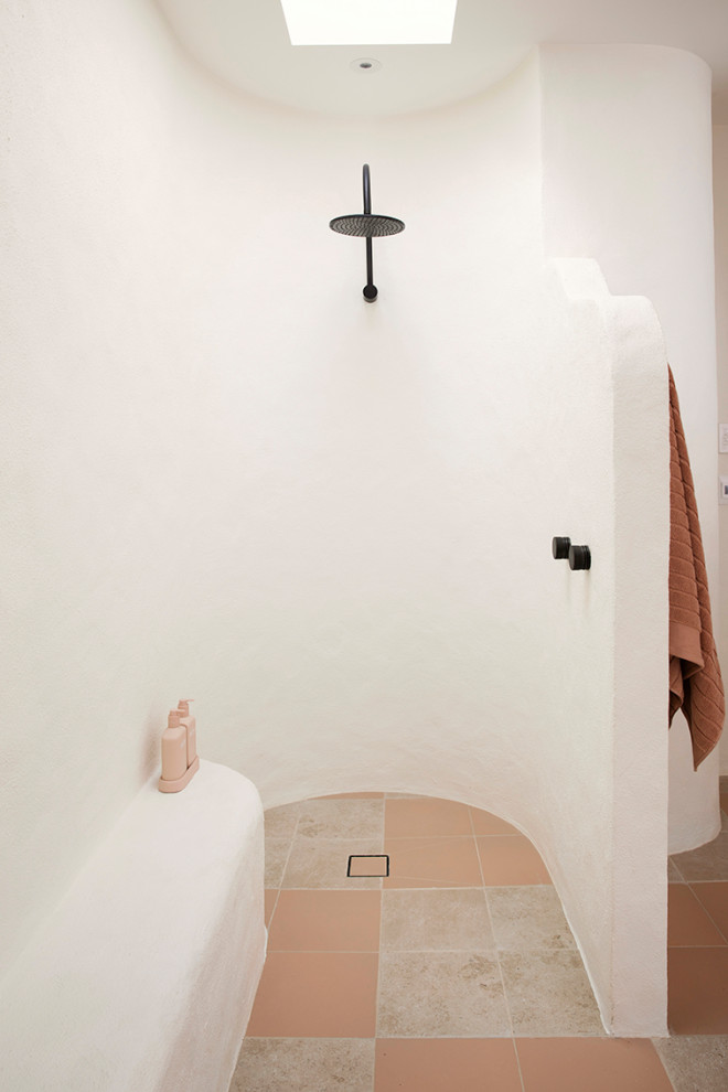 Cette photo montre une salle de bain méditerranéenne avec une douche ouverte, un mur blanc, un sol en carrelage de porcelaine, un sol multicolore, aucune cabine et un banc de douche.