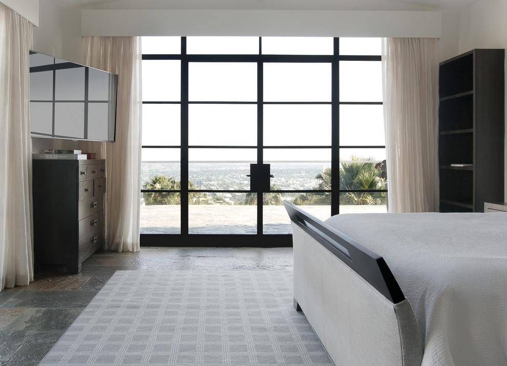 Inspiration for a large contemporary master bedroom in Los Angeles with white walls and slate floors.